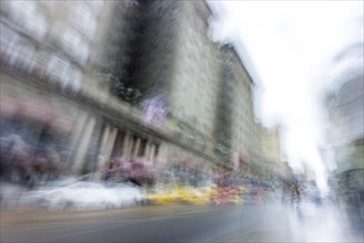 Blurred image of cars and people on city street