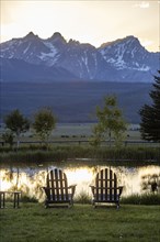 Scenic view of Sawtooth Mountains with pond at sunset