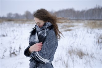 Portrait of freezing woman standing in snowy meadow