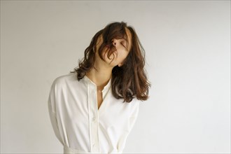 Portrait of young woman with closed eyes on white background