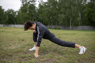 Young woman stretching legs before workout