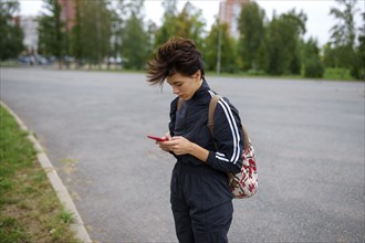 Young woman using smart phone in city street