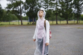 Portrait of young woman standing with closed eyes in rain