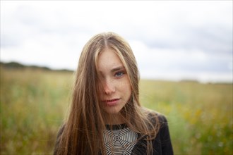 Portrait of blonde woman looking at camera in field