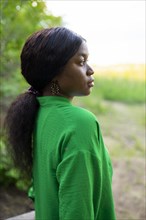 Side view of brunette woman wearing green blouse