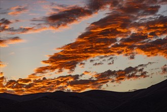 Silhouette of mountains with sunrise in background