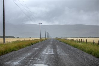 Rain clouds over dirt road in summer