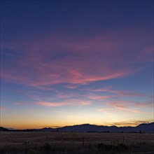 Sunset sky over agricultural fields and mountains