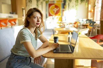 Portrait of woman working on laptop in cafe