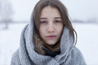 Portrait of serious woman with scarf in winter scenery