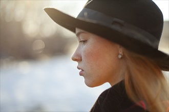 Portrait of young woman in hat on sunny day