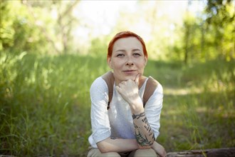 Portrait of smiling woman sitting on grass