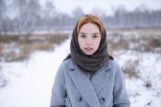 Portrait of young woman standing in snowy landscape