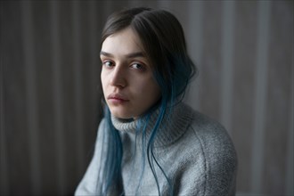 Portrait of serious woman in gray sweater