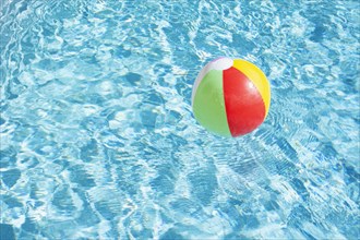 Beach ball floating on water in swimming pool