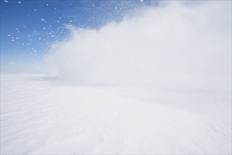 Blast of snow drifting blowing across frozen landscape, Hammond, NY, USA