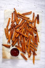 Overhead view of sweet potato fries and small bowl of ketchup