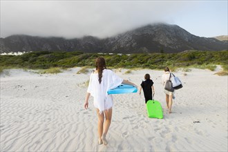 South Africa, Hermanus, Rear view of family walking on beach