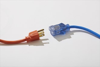 Studio shot of red and blue extension cords on white background