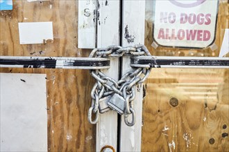 Close-up of chain and padlock on boarded up door
