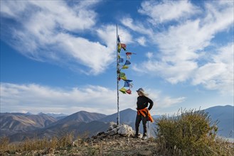 Female hiker atop Carbonate Mountain at prayer flags pole