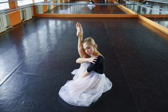 Ballerina sitting on floor in ballet studio