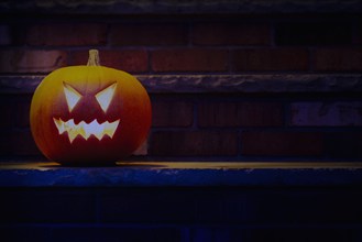 Illuminated Halloween jack-o-lantern on porch at night, Chatham, New Jersey, USA