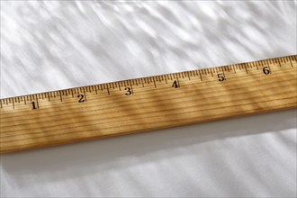 Close-up of wooden ruler on white background in sunlight, New York, NY, USA