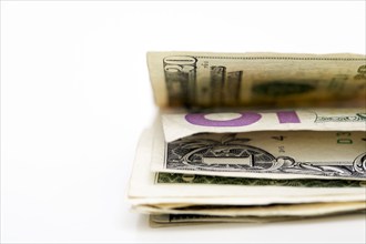 Close-up of folded dollar banknotes on white background, New York, NY, USA