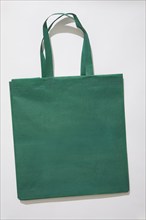 Green tote bag on white background, New York, NY, USA