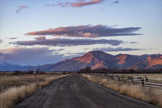 Empty dirt road leading to foothills at sunset, Bellevue, Idaho, USA