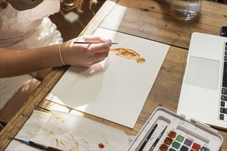 Close-up of teenage girl painting with watercolors at table, Lamy, New Mexico, USA