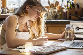 Teenage girl painting with watercolors at table, Lamy, New Mexico, USA