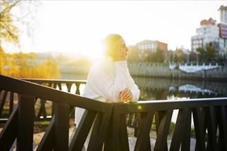 Woman in white sweater leaning on bridge, Omsk, , Russia