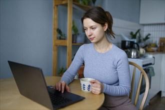 Woman using laptop at home, Omsk, , Russia