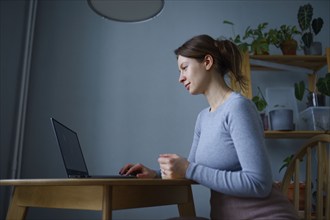 Woman using laptop at home, Omsk, , Russia