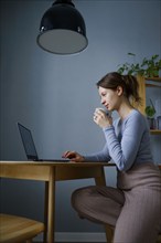 Woman using laptop at home, Omsk, , Russia