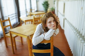 Portrait of pensive woman leaning on wooden chair, Omsk, , Russia