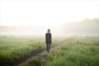 Rear view of woman standing in foggy field, Omsk, , Russia