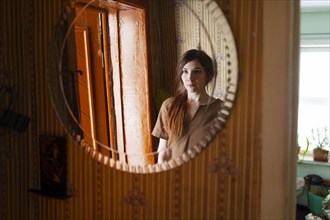 Portrait of woman reflected in round mirror, Omsk, , Russia