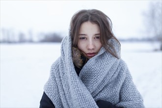 Portrait of woman wrapped in wool shawl in snowy landscape, Omsk, , Russia