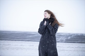 Portrait of woman in black coat in winter landscape, Omsk, , Russia