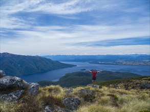 Portrait of hiker with arms outstretched in Fiordland National Park, Te Anau, Fiordland, New