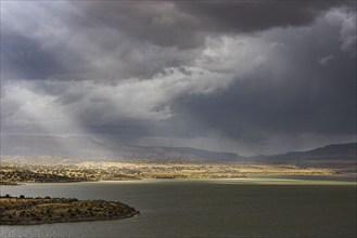 Usa, New Mexico, Abiquiu, Sun shining through storm clouds over Abiquiu Lake, Abiquiu, New Mexico,