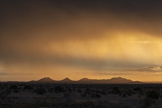 Usa, New Mexico, Santa Fe, Storm and rain over Cerrillos Hills at sunset, Santa Fe, New Mexico, USA