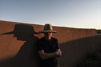 Usa, New Mexico, Santa Fe, Portrait of man in straw hat against adobe wall, Santa Fe, New Mexico,