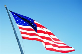 American flag blowing inn wind against clear sky, Hampstead, North Carolina, USA