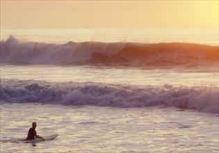 USA, NJ, Lone surfer on Spring Lake at sunrise, Spring Lake, New Jersey, USA