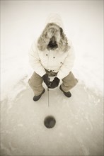 USA, NY, Hammond, High angle view of man ice fishing on frozen Black Lake, Hammond, Hammond, New