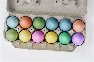 Overhead view of colorful Easter eggs in egg carton, New York, New York, USA